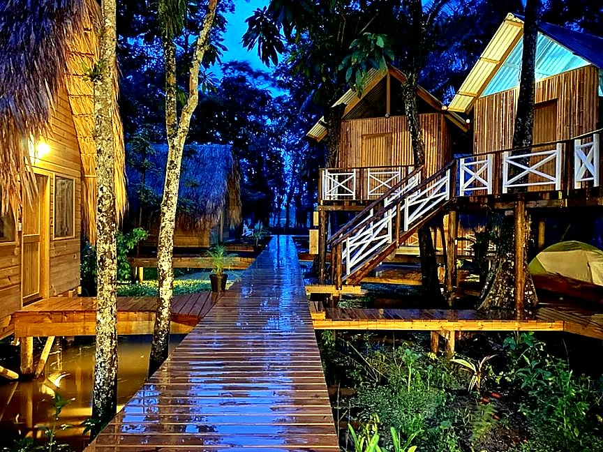 Night boardwalk over the water between cabins