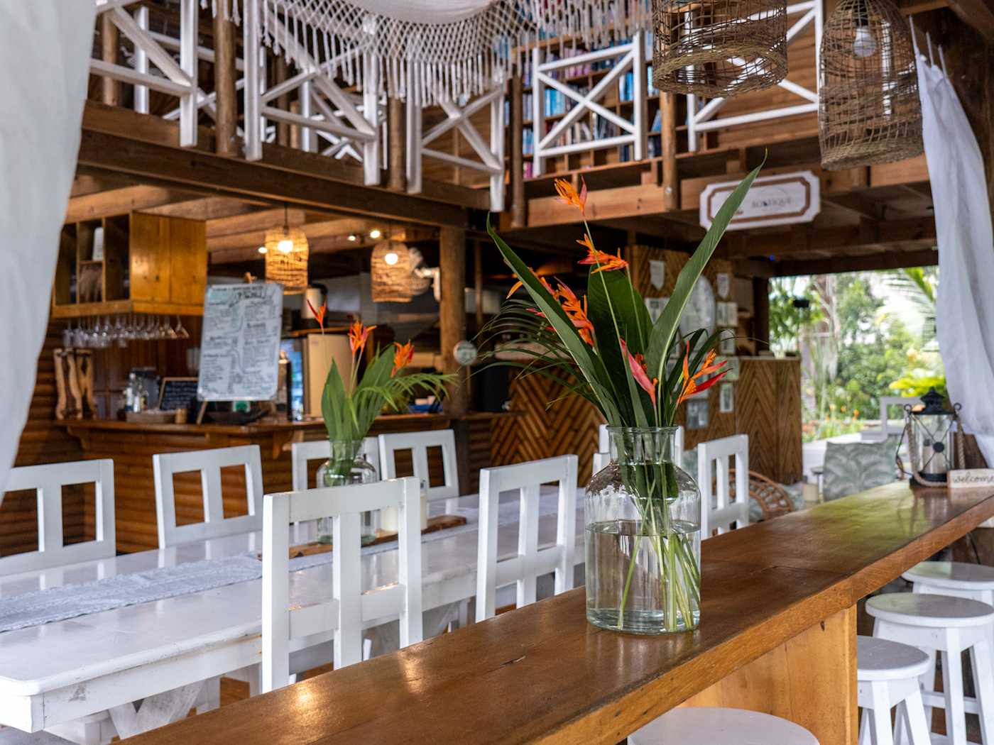 Long wooden dining table under a thatched roof